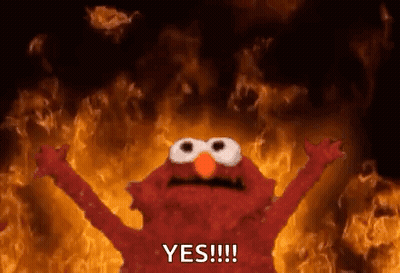 Elmo From Sesame Street Is Standing In Front Of A Fire With His Arms Outstretched And Saying Yes . GIF