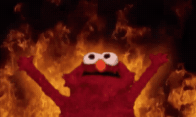Elmo From Sesame Street Is Standing In Front Of A Fire With His Arms Outstretched . GIF