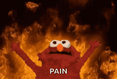 Elmo From Sesame Street Is Standing In Front Of A Fire With The Word Pain Written On It . GIF