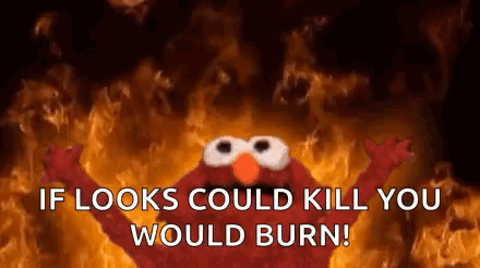 Elmo From Sesame Street Is Standing In Front Of A Fire . GIF