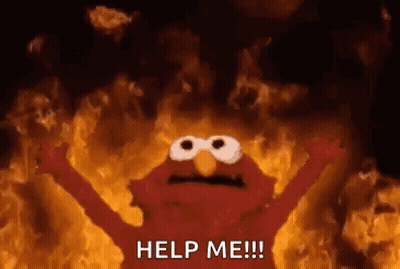 Elmo From Sesame Street Is Standing In Front Of A Wall Of Fire . GIF