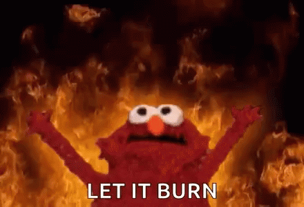 Elmo From Sesame Street Is Standing In Front Of A Wall Of Fire . GIF