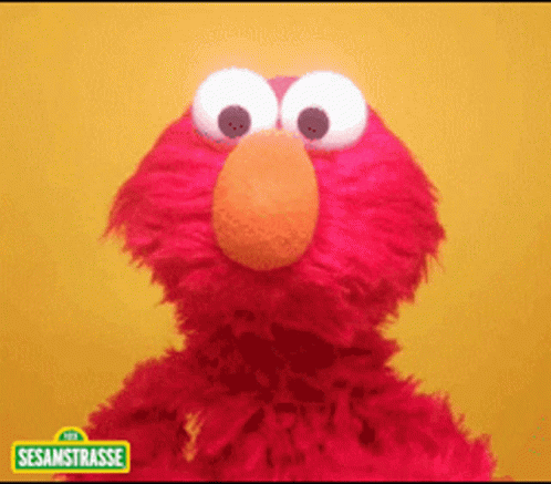 Elmo From Sesame Street Standing In Front Of A Yellow Wall GIF