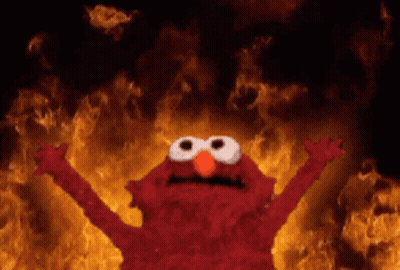 Elmo From Sesame Street Stands In Front Of A Wall Of Flames GIF
