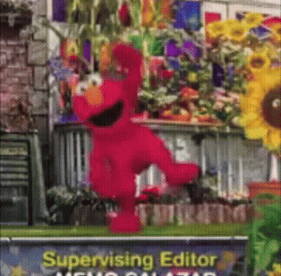 Elmo Is Dancing In Front Of A Sign That Says Supervising Editor GIF