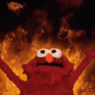 Elmo Is Standing In Front Of A Fire With His Arms Outstretched . GIF
