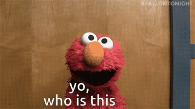 Elmo Says Yo Who Is This In Front Of A Wooden Door GIF