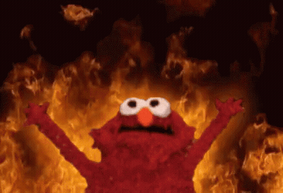 Elmo Standing In Front Of Wall Of Fire GIF