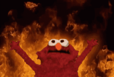 Elmo Standing In Front Of Wall Of Fire GIF