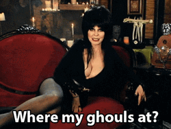 Elvira Lying On A Red Couch GIF