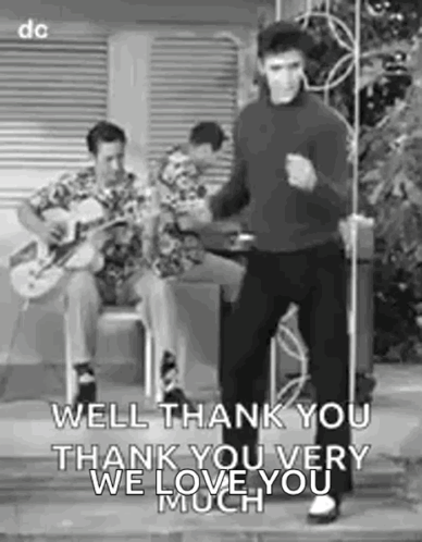Elvis Presley Is Dancing In A Black And White Photo While A Man Plays A Guitar In The Background . GIF