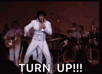 Elvis Presley Is Dancing On Stage While Singing Into A Microphone With The Words `` Turn Up ! '' GIF
