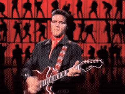 Elvis Presley Is Playing A Guitar On Stage In Front Of A Crowd GIF