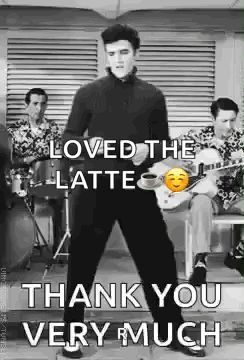 Elvis Presley Is Standing In Front Of A Group Of Men Playing Drums And Guitars . GIF