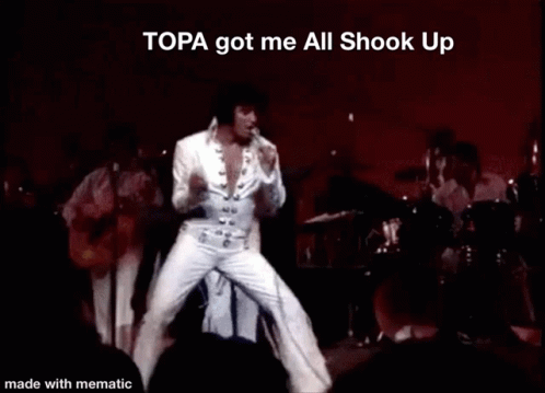 Elvis Presley Performing On Stage With The Words Topa Got Me All Shook Up Above Him GIF