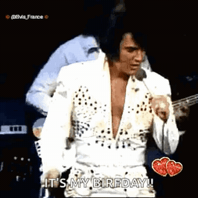 Elvis Presley Standing on Stage Singing Into Microphone