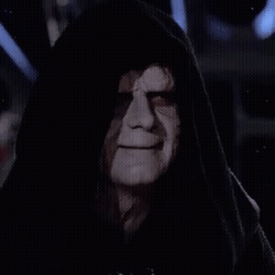 Emperor Palpatine From Star Wars Is Wearing A Hooded Robe And Looking At The Camera In The Dark . GIF