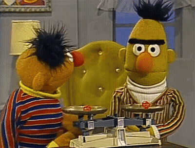Ernie And Bert From Sesame Street Are Sitting At A Table With A Scale GIF