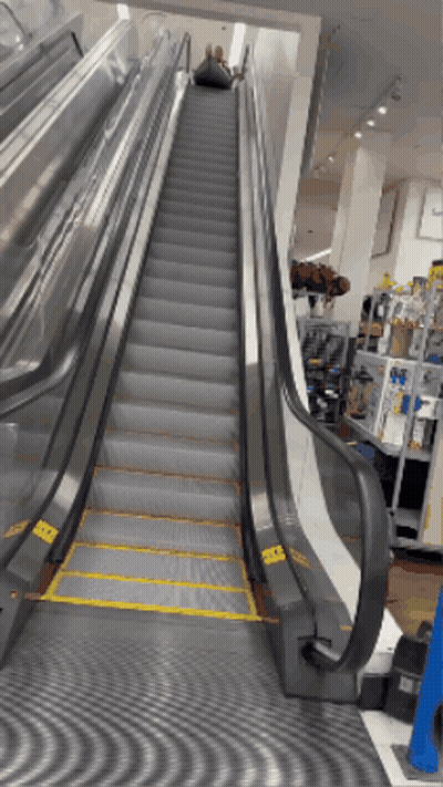 Escalator With Yellow Stripe On Bottom Steps GIF