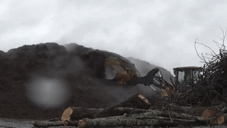 Excavator Making Mountains Of Mulch GIF