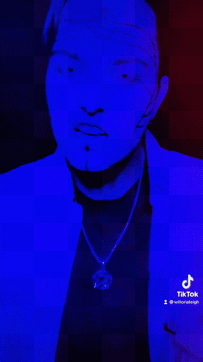 Face Lit Up With Blue Light Displaying TikTok GIF