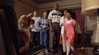 Family Standing In Living Room With Dog GIF