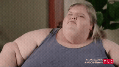 Fat Woman In Blue Tank Top Making Funny Face On Couch GIF