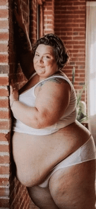 Fat Woman Leaning Against Brick Wall GIF