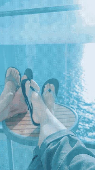 Feet Rest On Table Over Ocean GIF