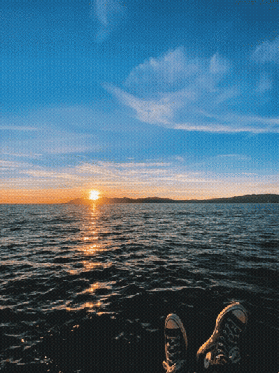 Feet Resting On Shore At Sunset GIF