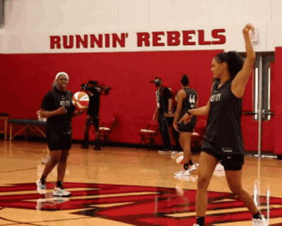 Female Basketball Players Practicing In Front Of Runnin' Rebels Wall GIF
