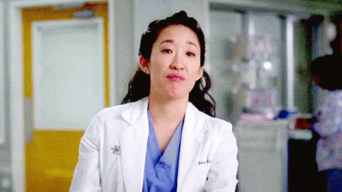 Female Doctor In White Lab Coat And Blue Scrubs Making Funny Face GIF