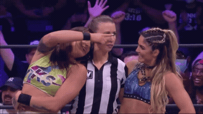 Female Wrestler Covering Eyes Beside Referee GIF