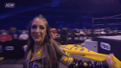 Female Wrestler Holding Yellow Flag In Front Of Crowd GIF