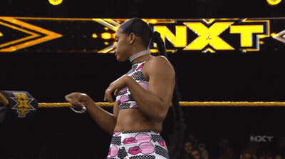 Female Wrestler In Front Of NXT Banner GIF