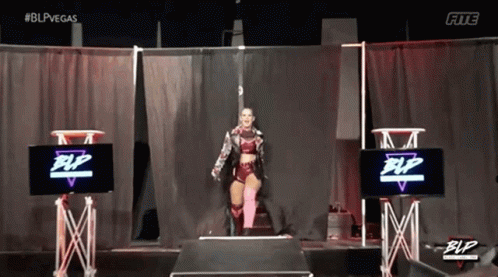 Female Wrestler On Stage In Front Of Screen GIF