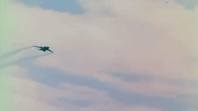 Fighter Jet Flying Through Blue Sky With Clouds GIF