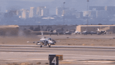 Fighter Jet Taking Off With Mountains And Buildings GIF