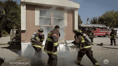 Firefighters In Front Of Mobile Home With Smoke GIF