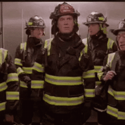 Firefighters Standing In Elevator With Helmets GIF