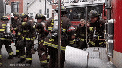 Firefighters Standing In Front Of Fire Truck Number 7 GIF