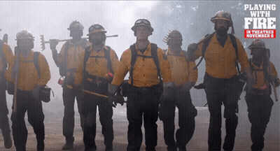 Firefighters Standing In Front Of Playing With Fire Sign GIF