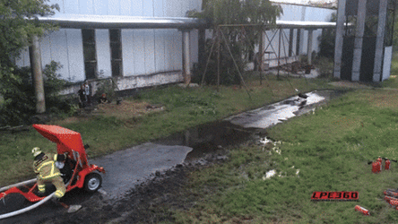 Fireman Splash Water At Flamethrower Using Fire Hose GIF