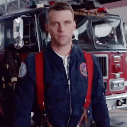 Fireman Standing In Front Of Fire Truck GIF