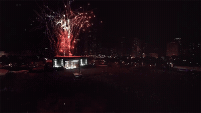 Fireworks Are Displayed In The Night Sky Above A Large Crowd GIF