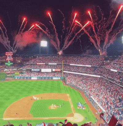 Fireworks Are Displayed Over A Baseball Field With A Post Advertisement GIF