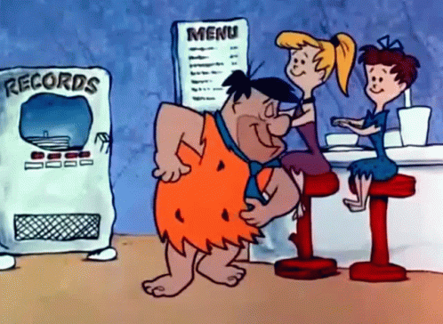 Flintstone Caveman Sitting at Restaurant Table