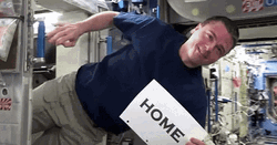 Floating Astronaut Holding Sign Home GIF