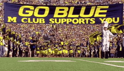 Football Field With Go Blue M Club Supports You Banner