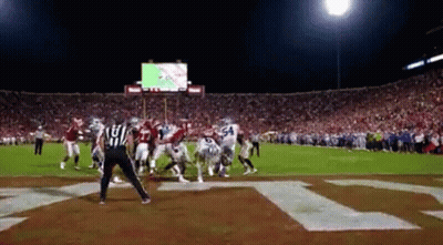 Football Game In Stadium With Letter T On Field GIF